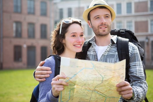 View of a Couple of young attractive tourists watching map