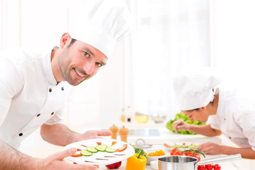 View of a Young attractive professional chef cooking in his kitchen