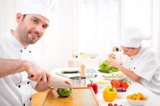 View of a Young attractive professional chef cooking in his kitchen
