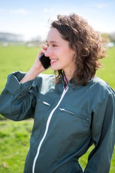 View of a Young attractive farmer in a field using mobile phone