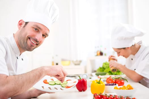 View of a Young attractive professional chef cooking in his kitchen