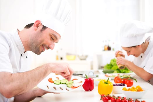 View of a Young attractive professional chef cooking in his kitchen