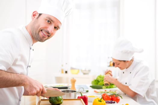 View of a Young attractive professional chef cooking in his kitchen