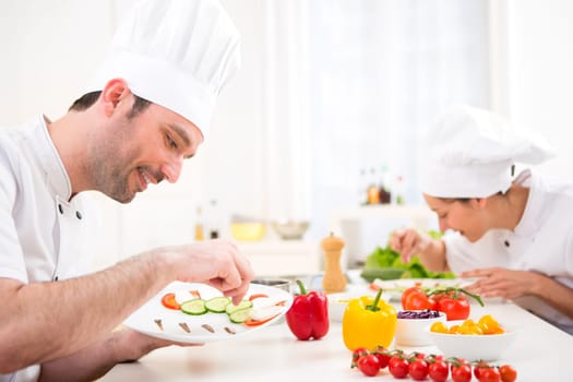 View of a Young attractive professional chef cooking in his kitchen