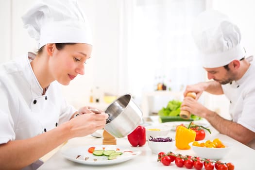 View of a Young attractive professional chef cooking in his kitchen