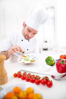 View of a Young attractive professional chef cooking in his kitchen