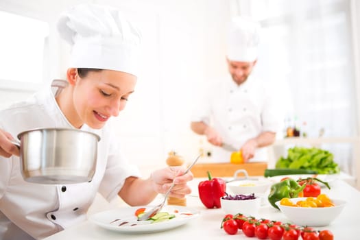 View of a Young attractive professional chef cooking in his kitchen