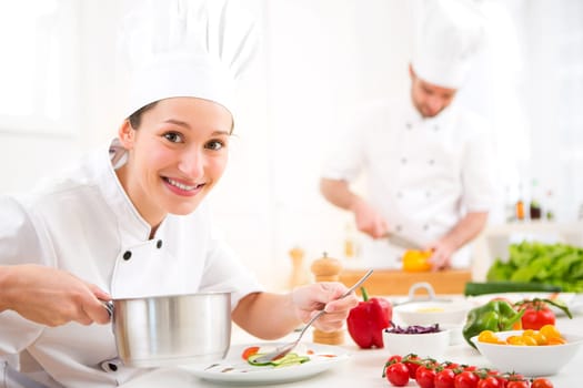 View of a Young attractive professional chef cooking in his kitchen