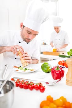 View of a Young attractive professional chef cooking in his kitchen