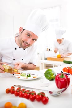 View of a Young attractive professional chef cooking in his kitchen
