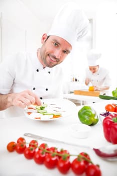 View of a Young attractive professional chef cooking in his kitchen