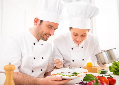 View of Young attractives professionals chefs cooking together