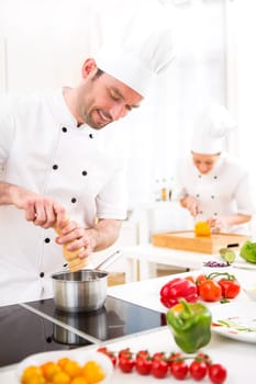View of a Young attractive professional chef cooking in his kitchen