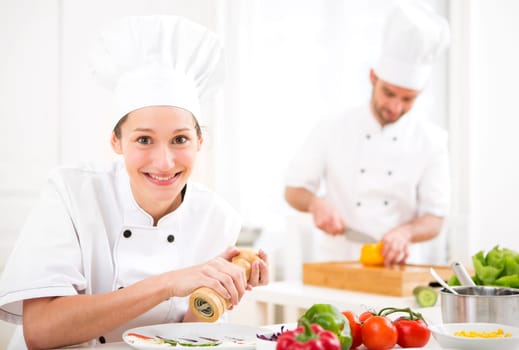 View of a Young attractive professional chef cooking in his kitchen