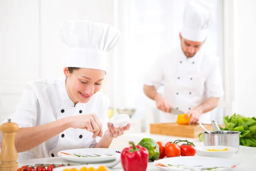 View of a Young attractive professional chef cooking in his kitchen