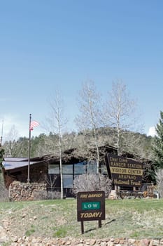 Idaho Springs, CO, USA - April 23, 2014: The Visitor Center and Clear Creek Ranger Station of the  Arapahoe National Forest. Vertical front view of a forest service building with trees, lawn and signs out front on a sunny day.