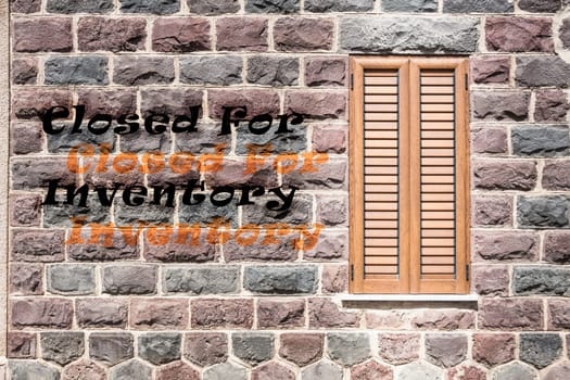 Window on the wall of basalt with written "Closed For Inventory"""