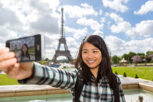 View of a Young attractive asian tourist in Paris taking selfie