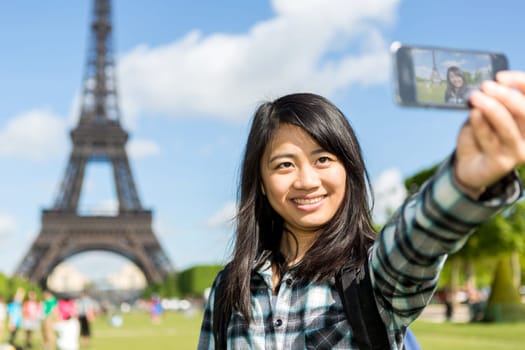 View of a Young attractive asian tourist in Paris taking selfie