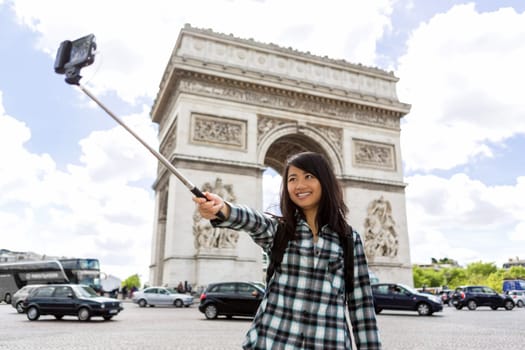 View of a Young attractive asian tourist in Paris taking selfie