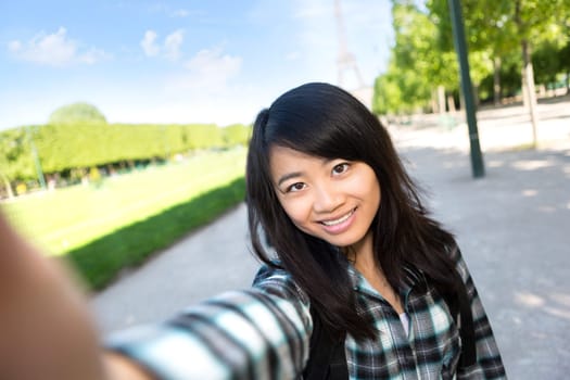 View of a Young attractive asian tourist in Paris taking selfie