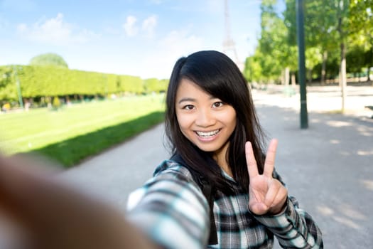 View of a Young attractive asian tourist in Paris taking selfie