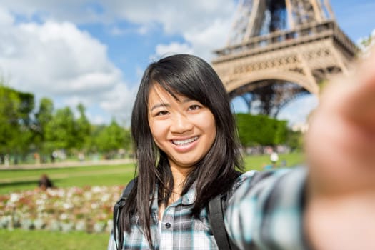 View of a Young attractive asian tourist in Paris taking selfie