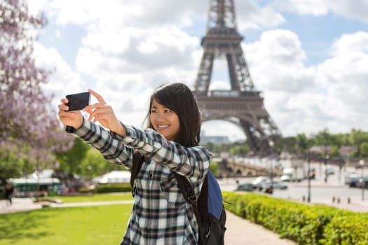 View of a Young attractive asian tourist in Paris taking selfie