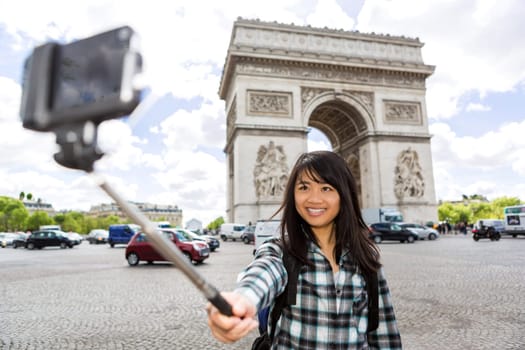 View of a Young attractive asian tourist in Paris taking selfie
