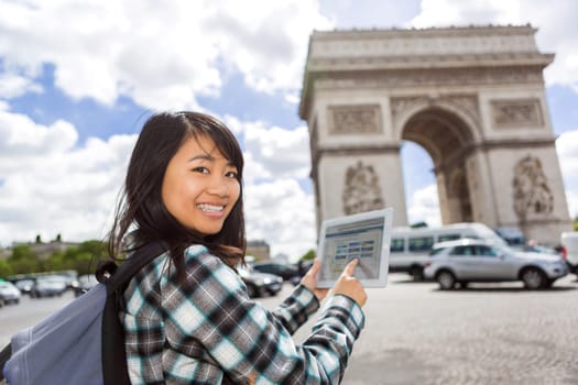 View of a Young attractive asian tourist using tablet in Paris