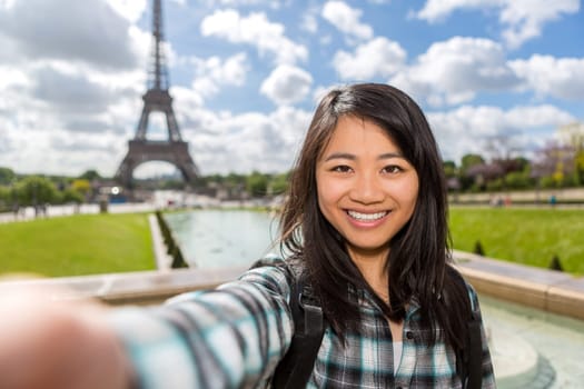 View of a Young attractive asian tourist in Paris taking selfie