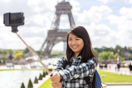 View of a Young attractive asian tourist in Paris taking selfie