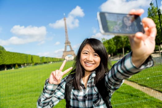 View of a Young attractive asian tourist in Paris taking selfie