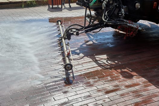 A special machine washes city paths and roads with water. High quality photo