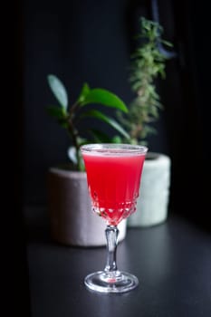 Soft focus photo of scofflaw cocktail on bar counter. Image with shallow depth of field and contains a little noise due to poor lighting conditions.