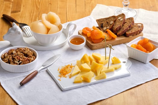 Set of various appetizers for wine - cheese, walnuts, dried apricots, honey and canned pear