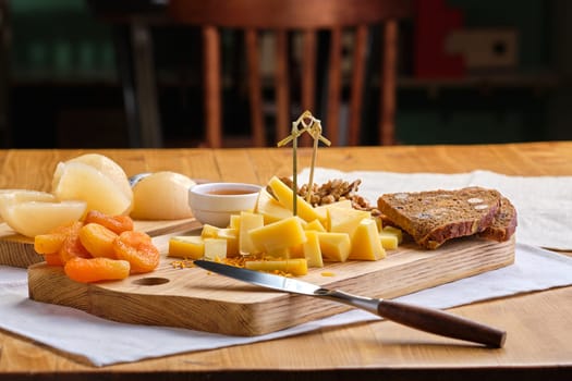 Set of various appetizers for wine - cheese, walnuts, dried apricots, honey and canned pear