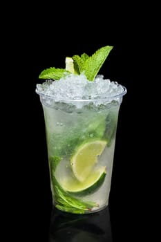 Cold lime and mint cocktail with a sparkling wine with ice in take away glass isolated on black