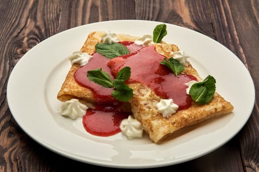 delicious juicy pancakes drizzled with sauce are served on a white plate. High quality photo