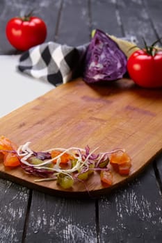Fresh vegetables on wooden board with a napkin on a table.