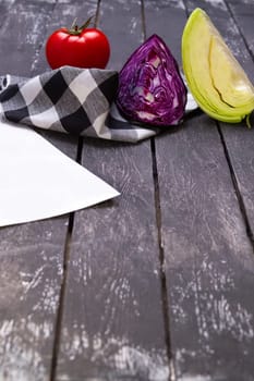 Fresh vegetables on wooden board with a napkin on a table.