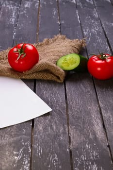 Fresh vegetables on wooden board with a napkin on a table.