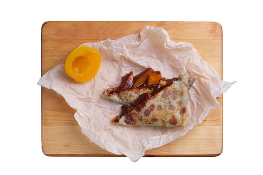 Thin pancakes stuffed with apricot and soft cheese isolated on white