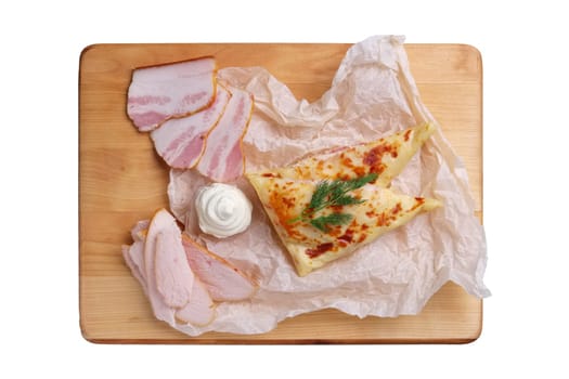 Thin pancakes stuffed with ham and bacon isolated on white