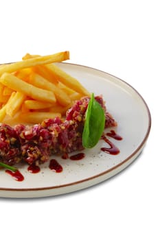 Beef tar tar  with balsamic sauce, basil and french fries isolated on white