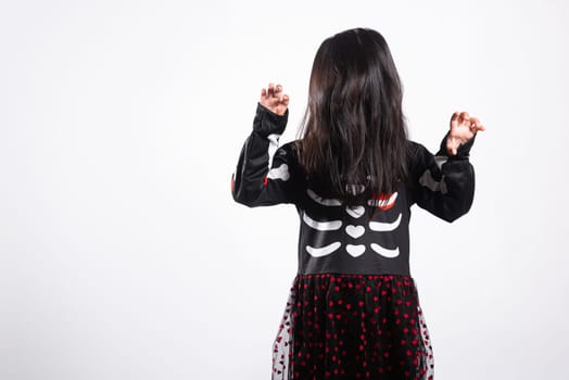 Asian little kid girl with face painting and hair covering face, woman child ghost or zombie horror creepy scary skeleton costume studio shot isolated on white background, Happy Halloween day concept