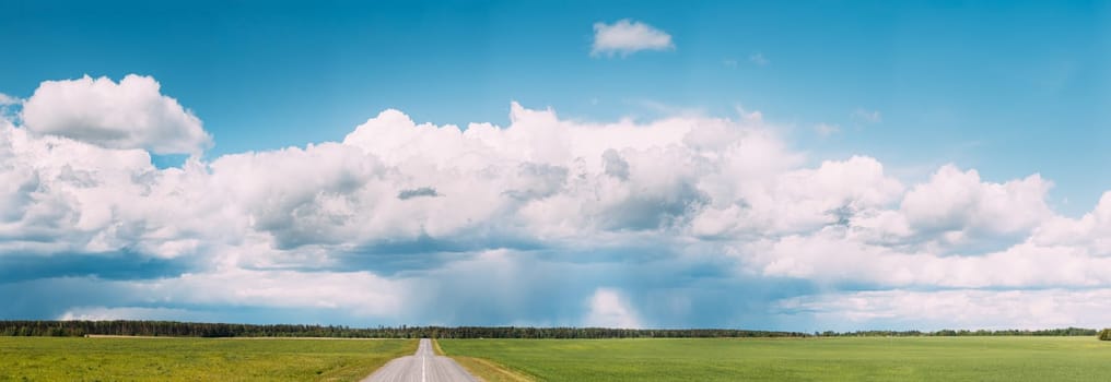 Panoramic View Of Open Asphalt Countryside Road Through Fields Or Meadows. Sunny Day White Clouds On Blue Sky.