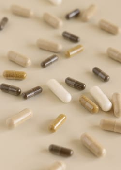 Mix of medical capsules on light beige close up. Preventive medicine and healthcare, taking dietary supplements and vitamins. Assorted pharmaceutical medicine capsules