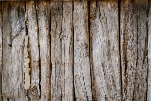 front view closeup of rustic weathered brown barn wood background with knots and nail holes