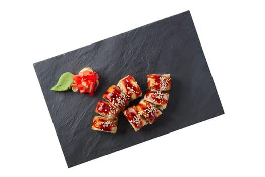 Portion of unagi roll with garnish isolated on white